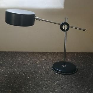 A black metal and aluminium desklamp on leather base