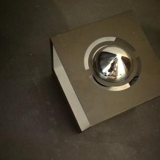 A small bronzecoloured metal cube lamp