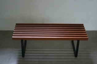 A small slated bench on metal feet